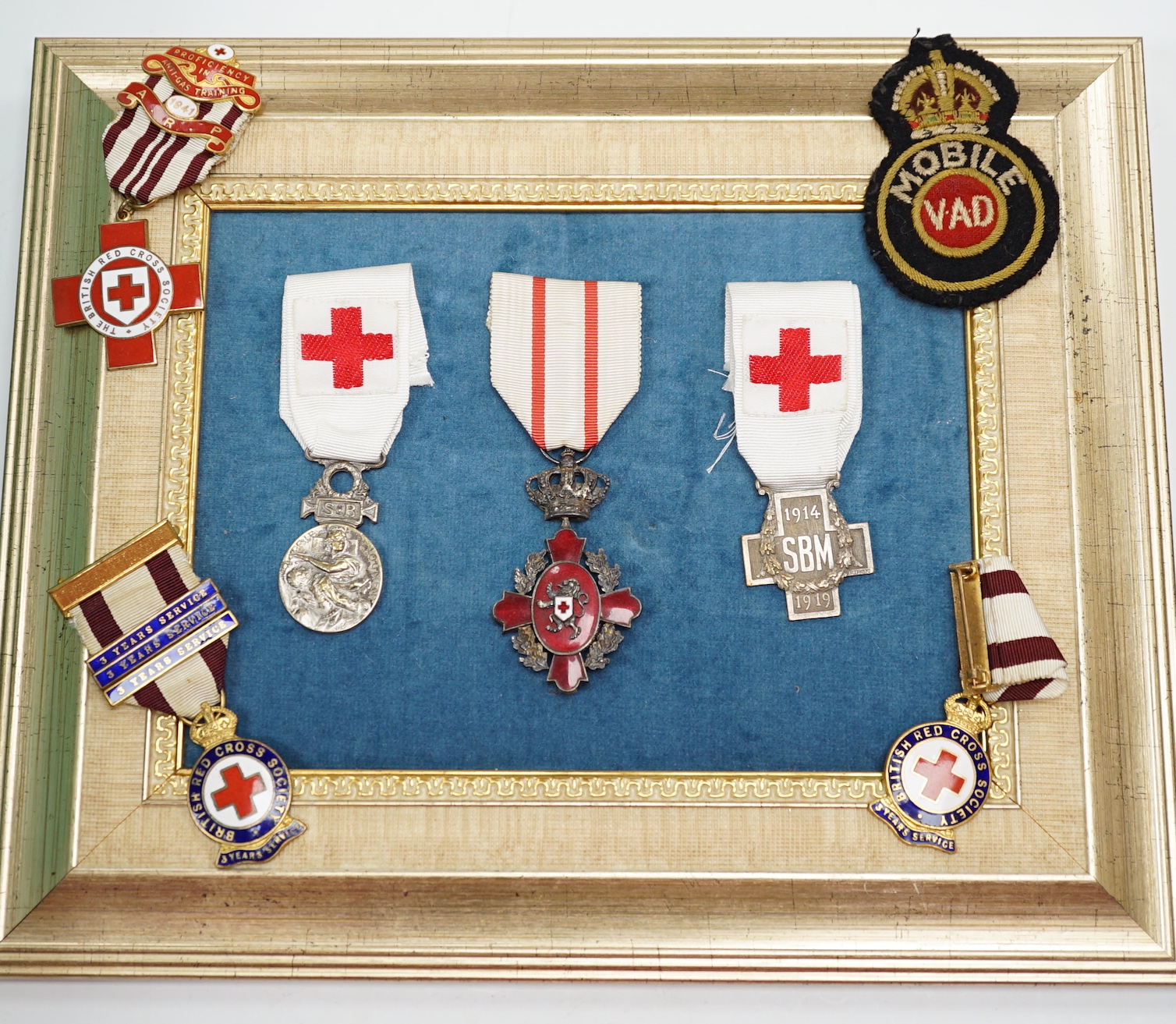 A collection of British Red Cross, medals, badges and memorabilia including a brass plaque, commemorating an auxiliary hospital during the Great War, proficiency, medals, long, service, medals, metal boxes, and some pape